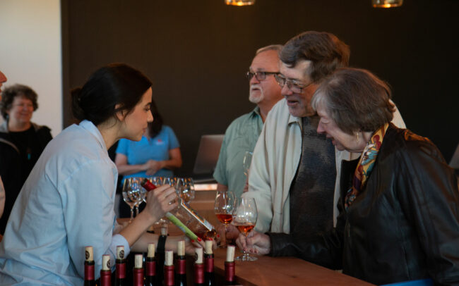 Tasting room staff showing a bottle of Rosé to guests during a tasting